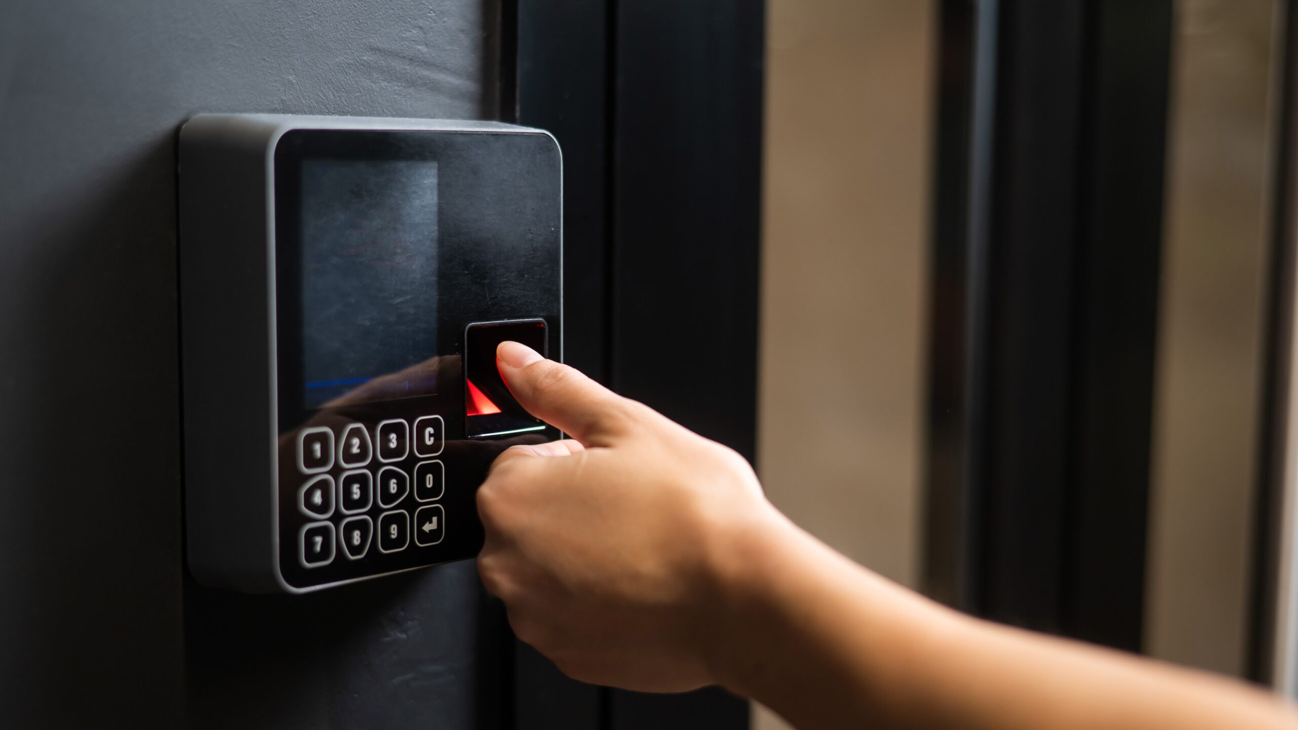 Close up of woman using fingerprint to access a building.