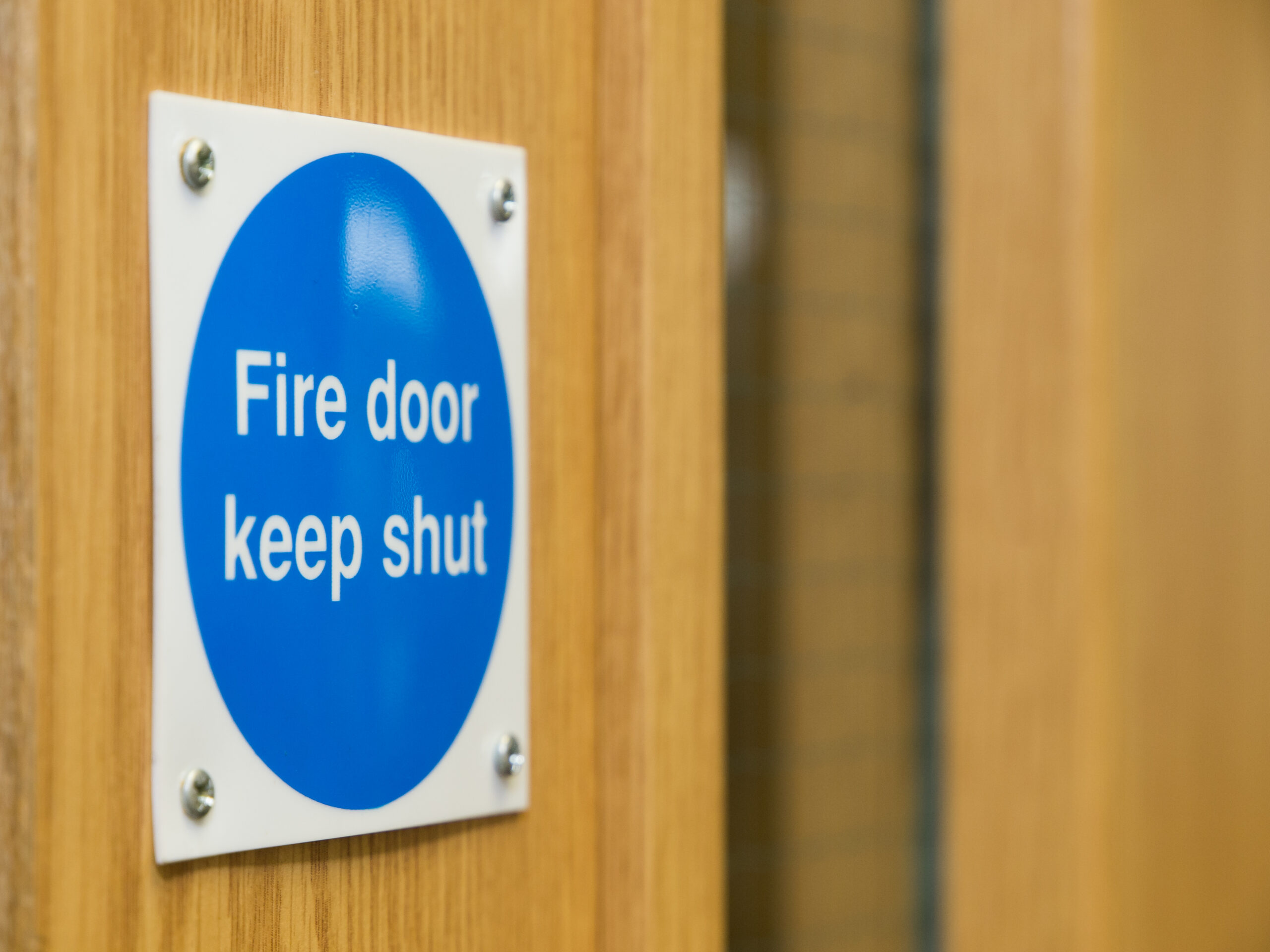 Fire Door Keep Shut Sign on a Wooden Fire Door
