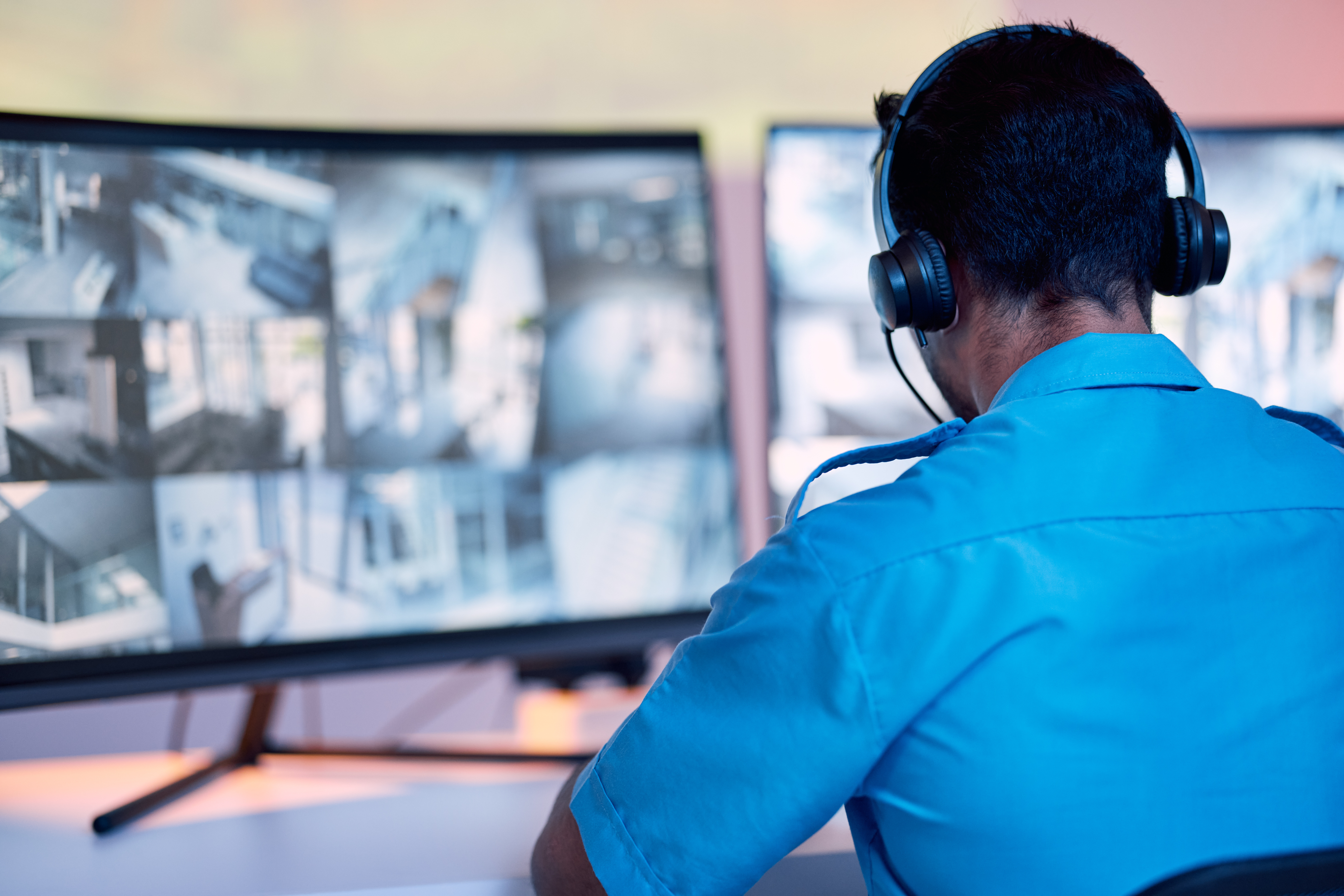 Security guard with headphones and cctv monitor